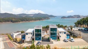 Ein Hotel mit Blick auf eine Küstenlandschaft, das zwei markante Gebäude mit 'Well Stay'-Beschilderung zeigt.