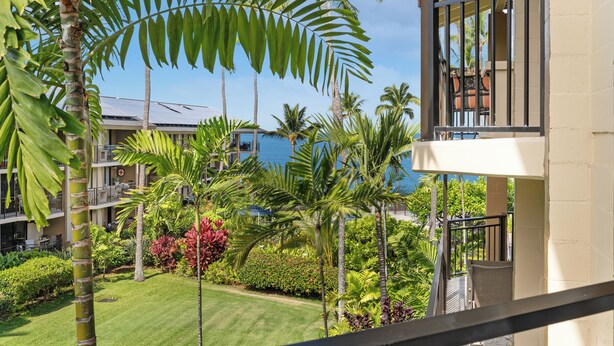 Un hôtel doté d’un balcon, d’une végétation luxuriante et offrant une vue sur l’océan.