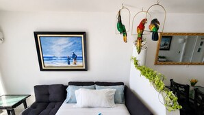 A modern bedroom with a large bed, a sofa, a dining table, and a framed picture on the wall. - Ocean view with balcony—pool—Bocagrande Beach—Pet-friendly (Cartagena de Indias)