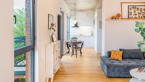 Un salon moderne avec un canapé, une table à manger et une cuisine en arrière-plan.