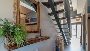 A modern interior with a wooden shelf, a mirror, and a staircase. - Seaside Suite 4 -Modern & Comfort (Episkopos)