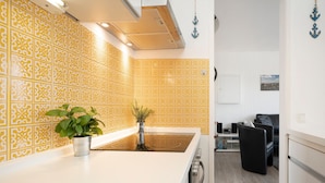 Una cocina moderna con baldosas amarillas estampadas, una encimera blanca y una planta en maceta.