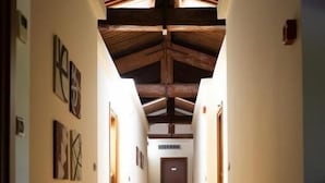 A hallway with wooden floors and a sloped ceiling, leading to a door at the end. - Tenuta Molino dei Sassi (Zevio)