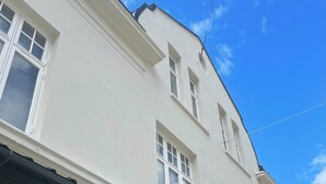 Ein weißes Gebäude mit vielen Fenstern und blauem Himmel.