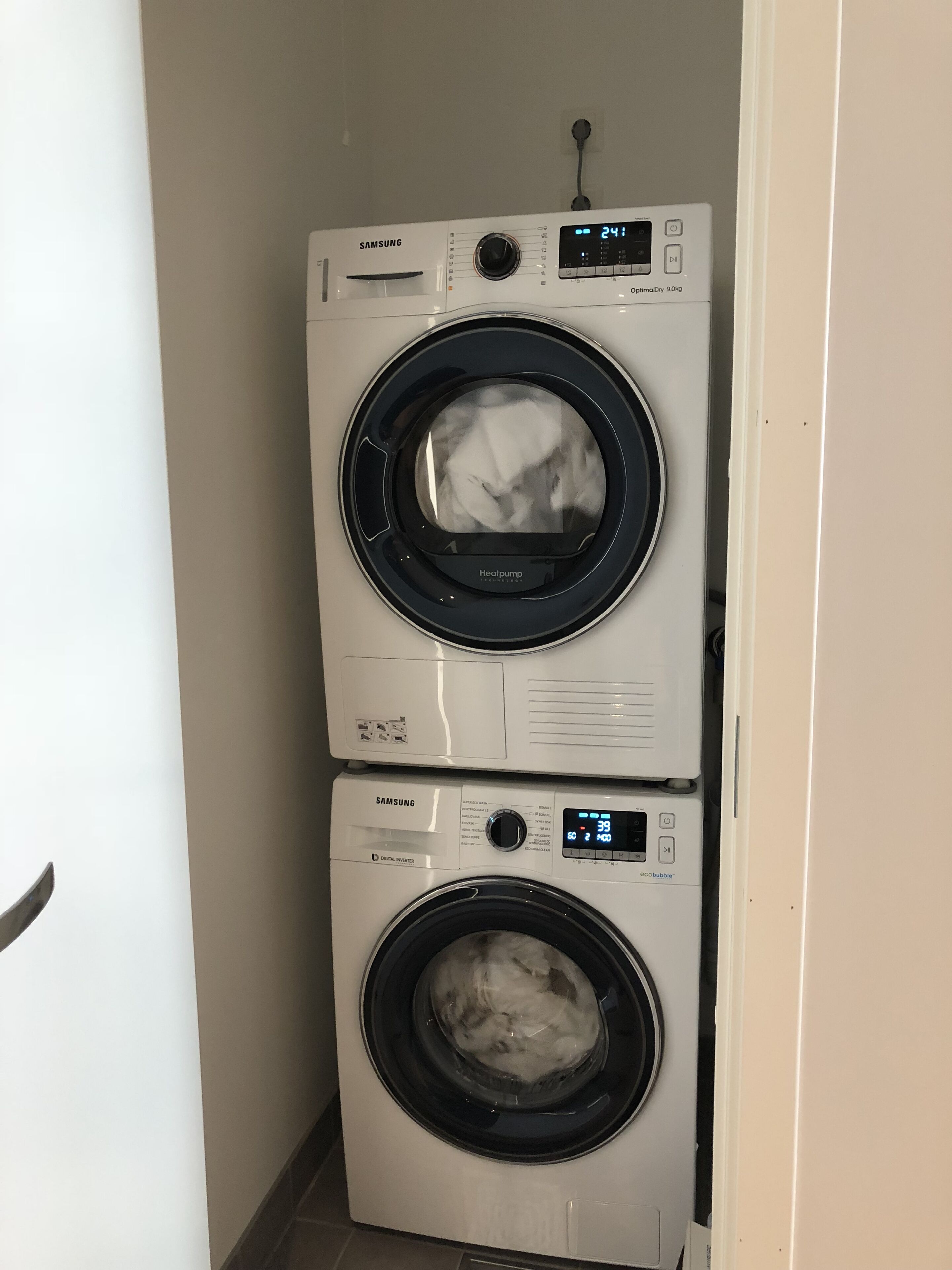 Twee Samsung wasmachines, boven elkaar, in een wasserij.