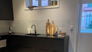 Eine moderne Küche mit schwarzem Arbeitsplatz, einem Spülbecken und einem Fenster darüber.