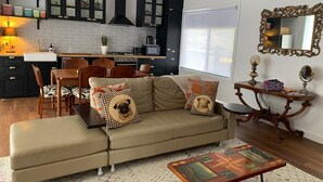 A modern living room with a sofa, coffee table, and dining area. - La Maisonnette (Daylesford)