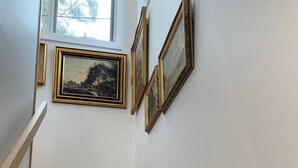 A wooden staircase with white walls and framed artwork. - La Maisonnette (Daylesford)