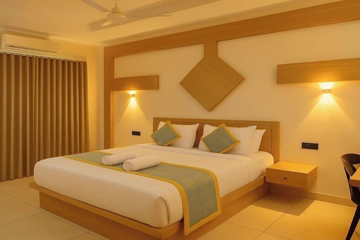 Ein Hotelzimmer mit einem großen Bett, Nachttischen, einem Schreibtisch und einem Sessel.