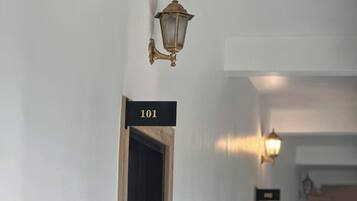 A hallway with a door labeled "101" and a wall-mounted light fixture.