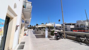 A seaside street with outdoor seating, a cafe, and a view of the sea. - Holiday House "idrusa" in Otranto (Otranto)