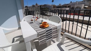 A balcony with a table set for two, a cup, and a bottle. - Holiday House "idrusa" in Otranto (Otranto)