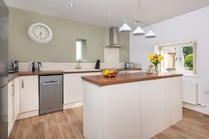 Enjoy cooking in this well-equipped kitchen with a central island, dishwasher, and ample counter space.
