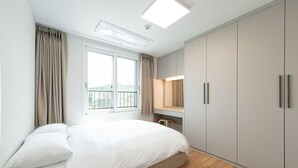A modern bedroom with a large bed, a desk, and a wardrobe. - GUDO RESIDENCE CHUNGMURO (Seoul)
