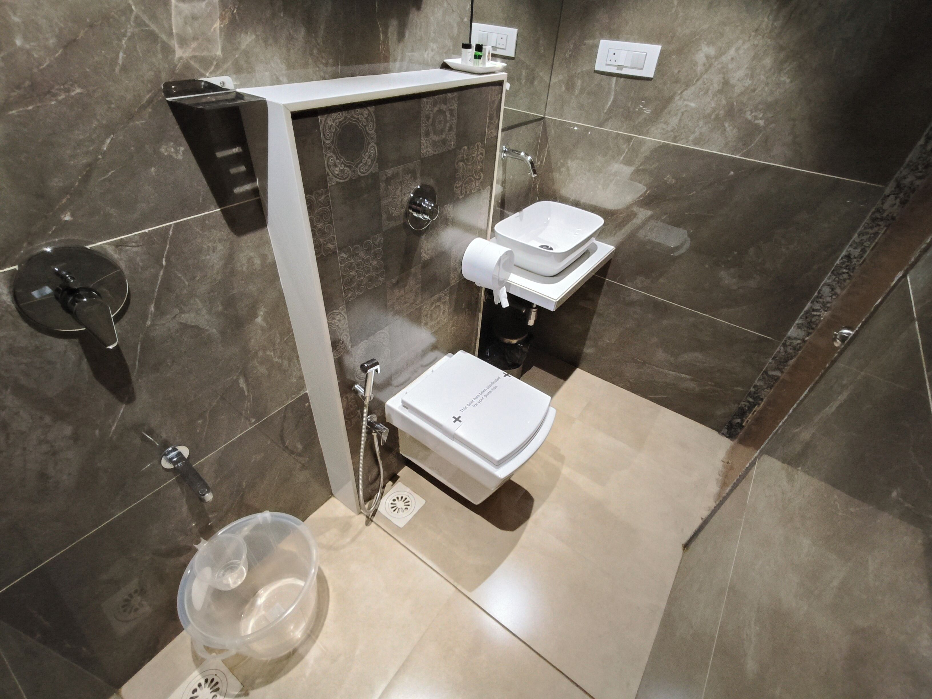 A modern bathroom with a shower, two sinks, and a toilet.