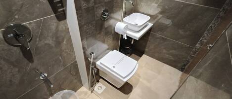 A modern bathroom with a shower, two sinks, and a toilet.