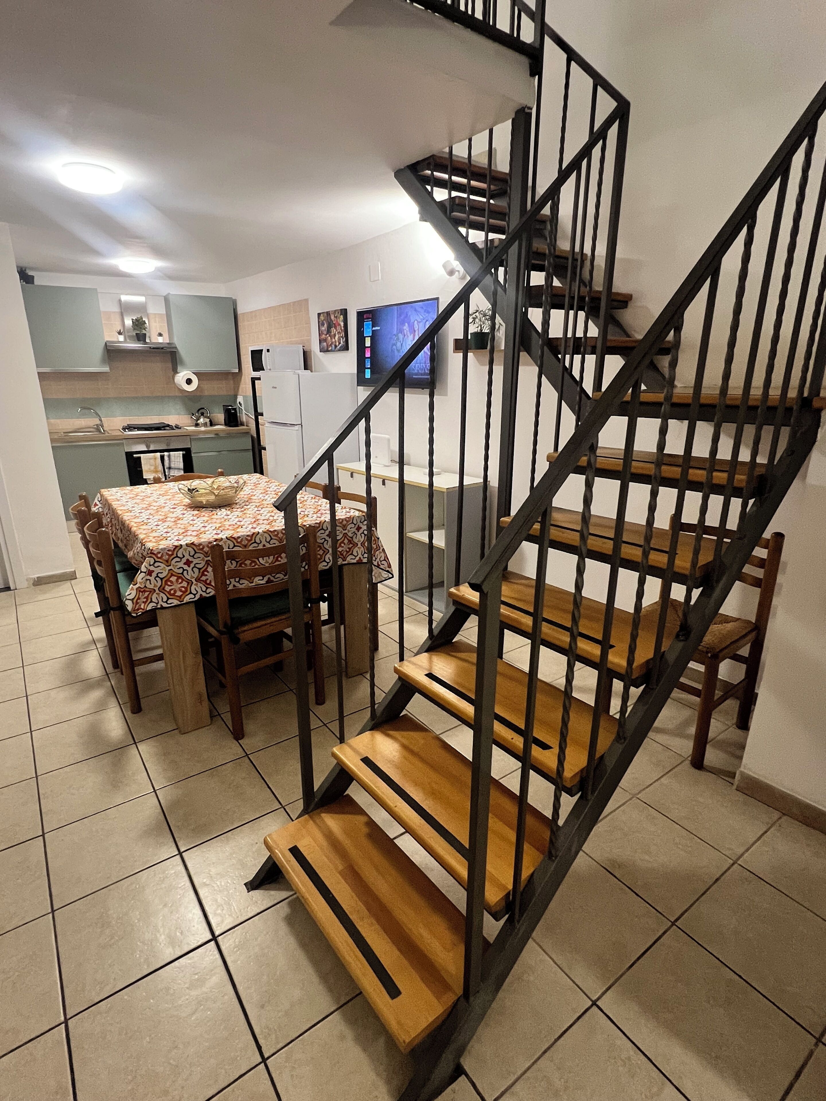 A staircase with wooden steps and metal railings leading to an upper floor.