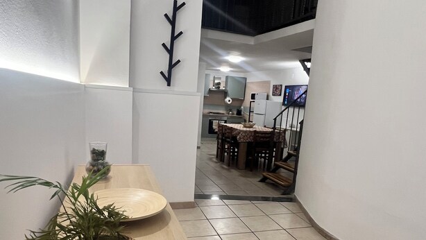 A modern kitchen with a wooden countertop, a potted plant, and a dining area with a table and chairs. - Boaters' Home 2, Catania (Catania)
