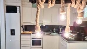 Une cuisine avec des armoires blanches, un four encastré, un four à micro-ondes et un évier.