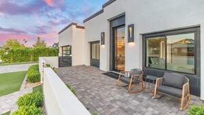 A modern building with a patio area featuring outdoor seating and a well-maintained garden. - NEW The Casa Privada Experience (Scottsdale)