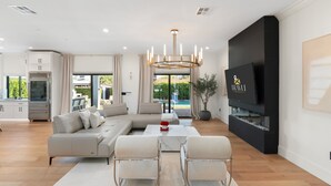 A modern living room with a sectional sofa, a coffee table, and a TV. - NEW The Casa Privada Experience (Scottsdale)