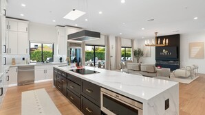 A modern kitchen with a large island, built-in appliances, and a view to the outdoors. - NEW The Casa Privada Experience (Scottsdale)