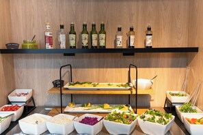 A buffet setup with various food items and condiments. - Sea & Forest Resort Międzyzdroje (Miedzyzdroje)