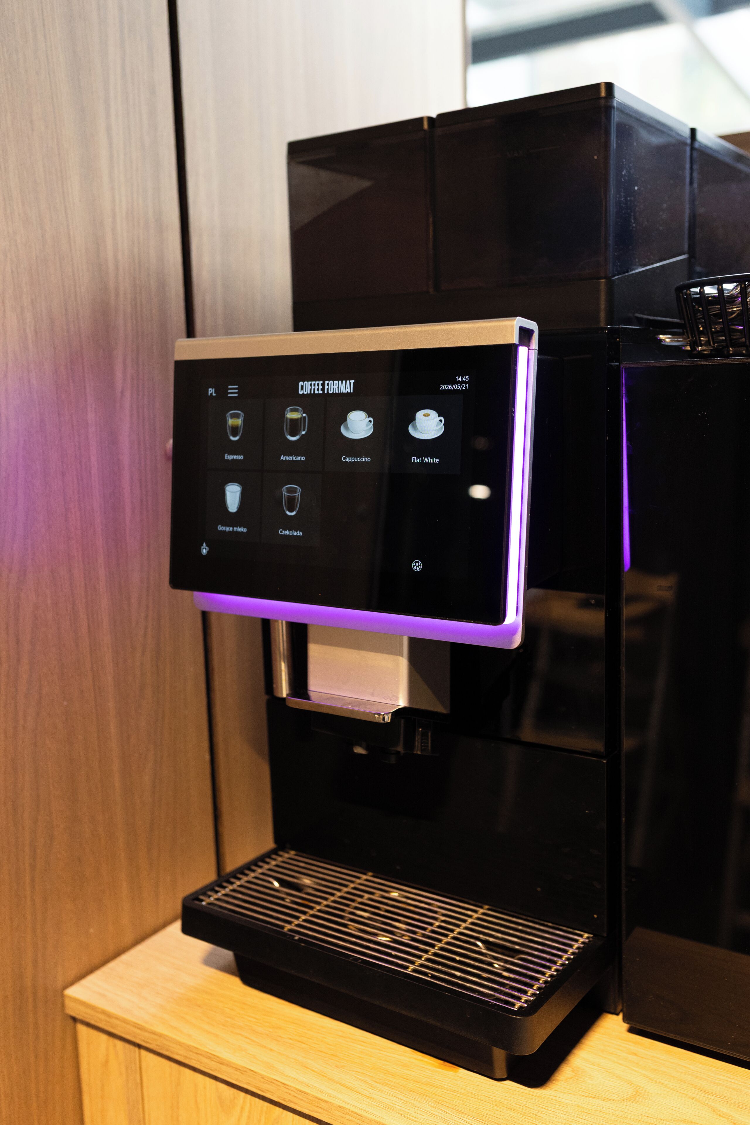 A coffee machine with a digital display and a selection of coffee formats.