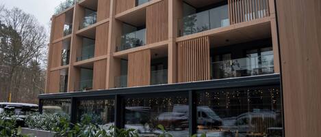 A multi-story building with a modern architectural design, featuring large windows and balconies.