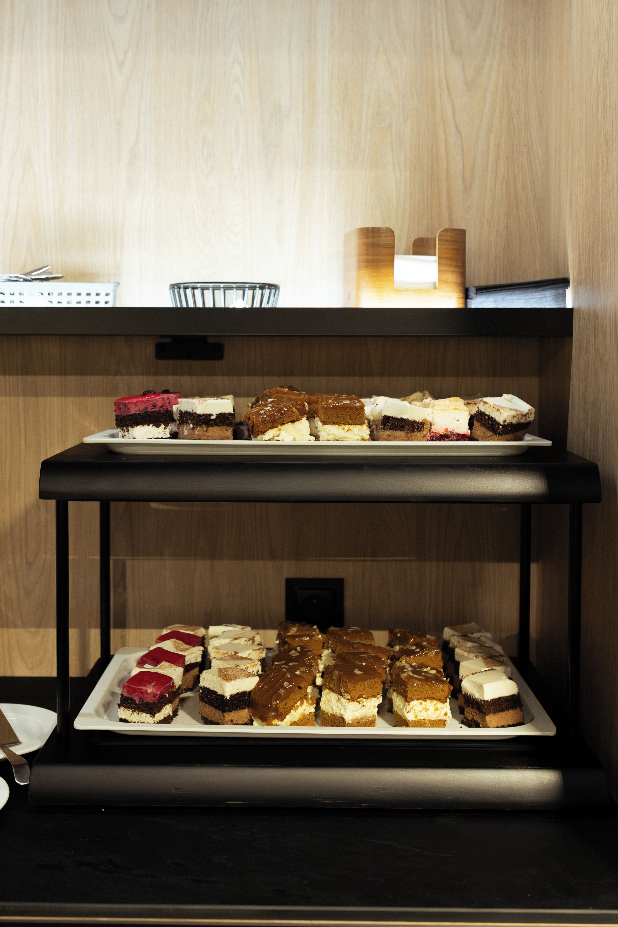 A buffet with various desserts arranged on trays.