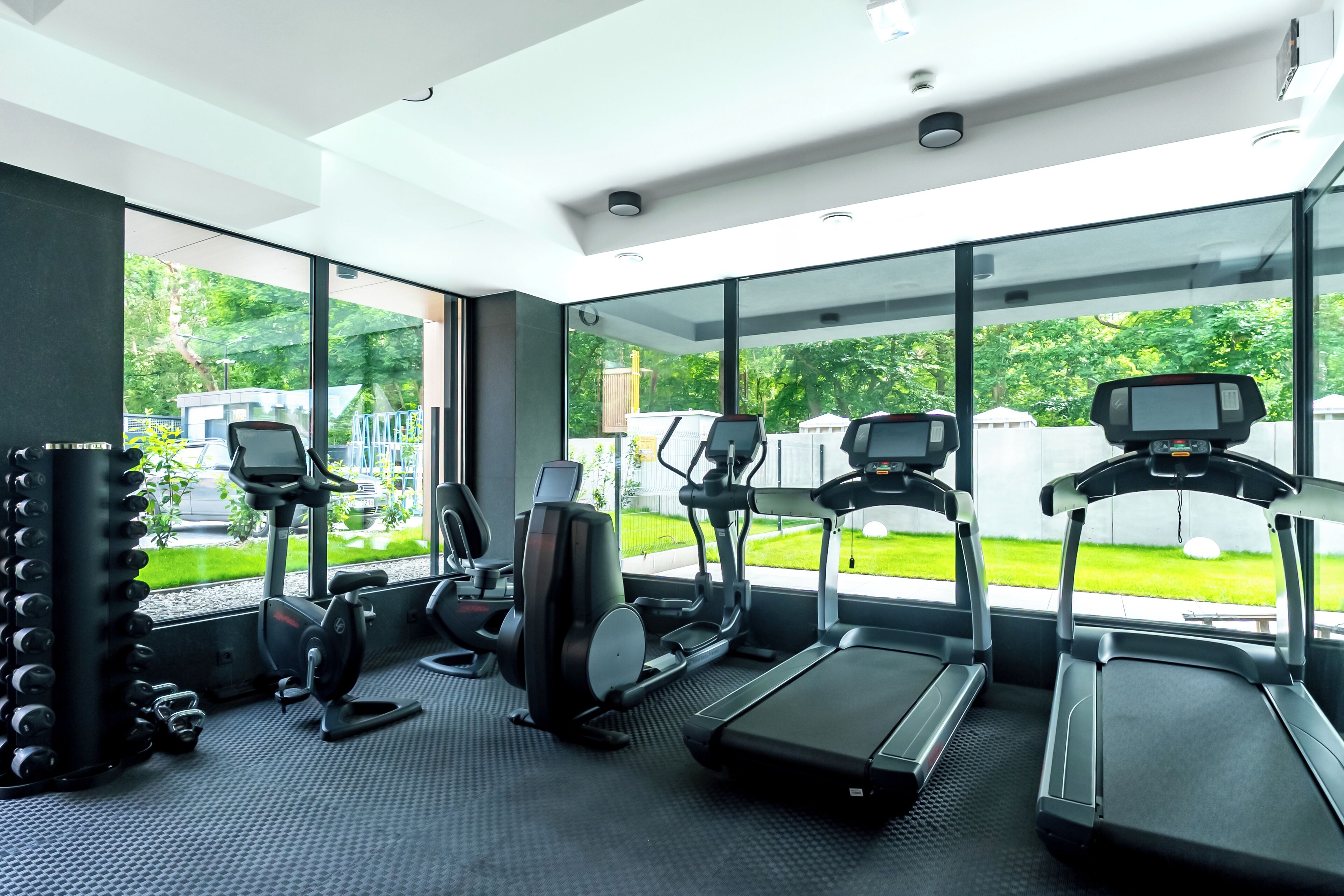 Ein modernes Fitnessstudio mit Laufbändern, Crosstrainern und Kraftgeräten.