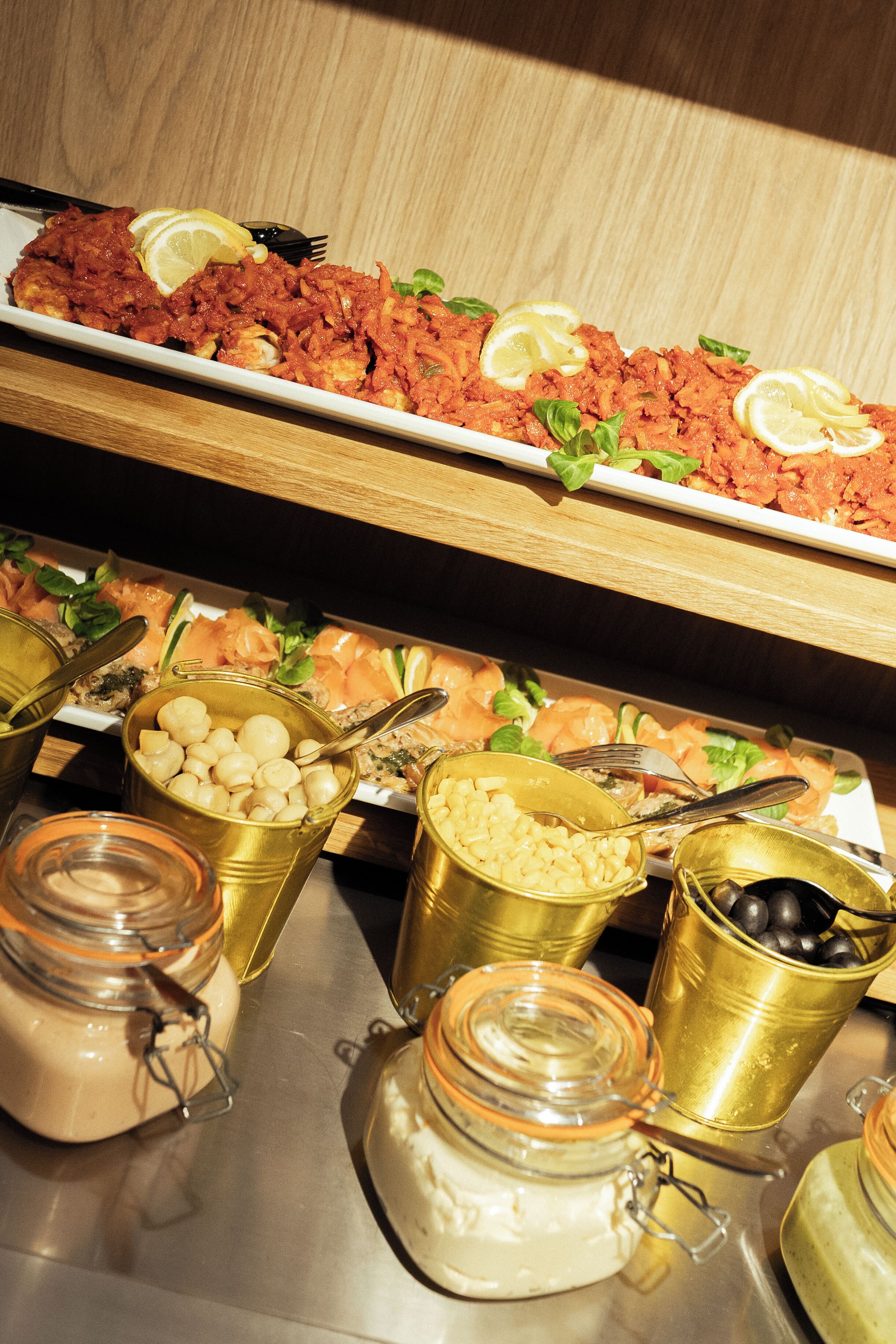 A buffet with various food items and condiments.