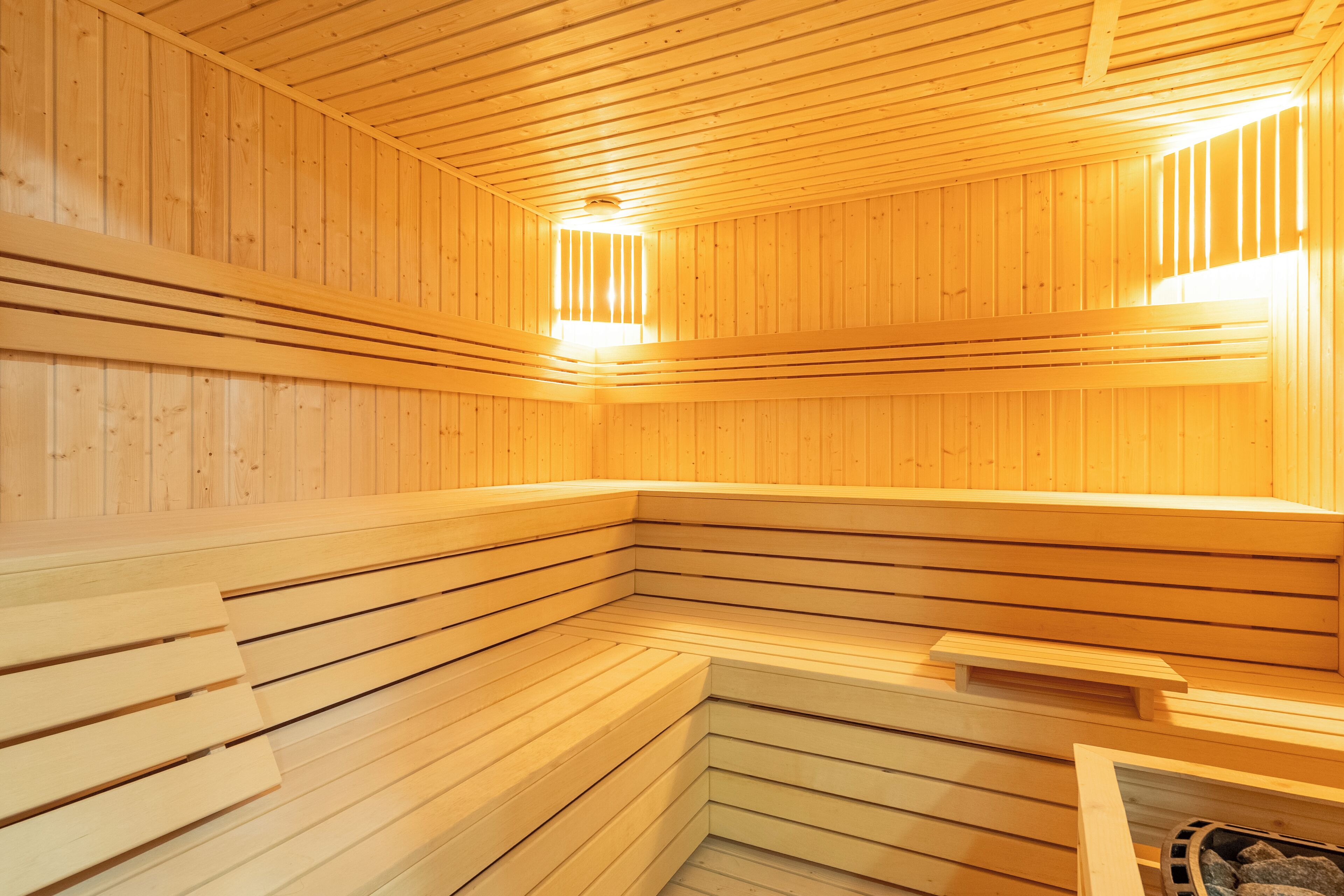 Una sauna amb seients de fusta i sostre inclinat.