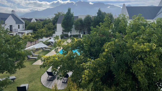Ein Resort mit Pool, Liegestühlen und Bergblick.