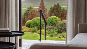 Ein Zimmer mit Blick auf einen Weinberg und sanfte Hügel.