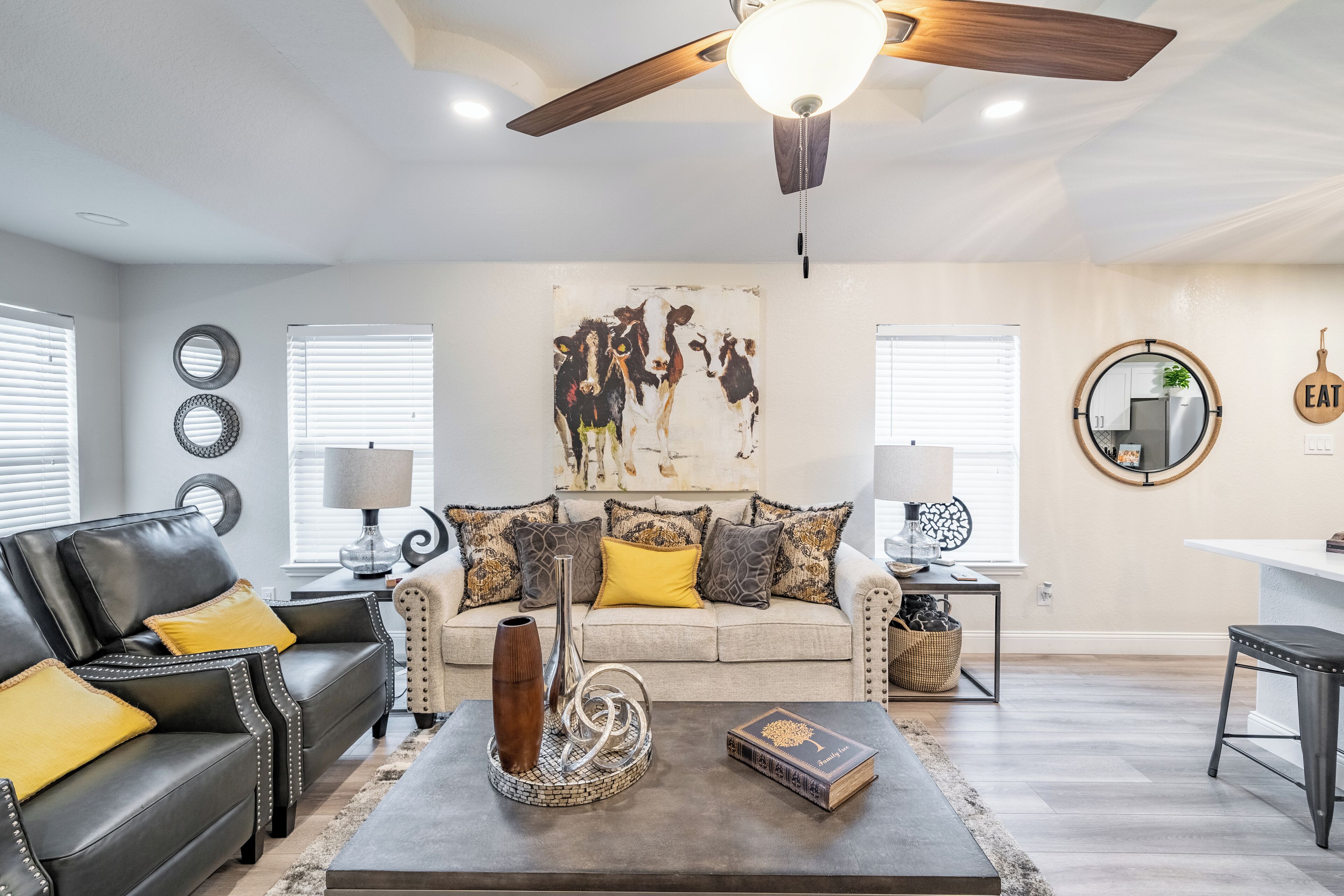 A modern living room with a sofa, coffee table, and artwork on the wall.