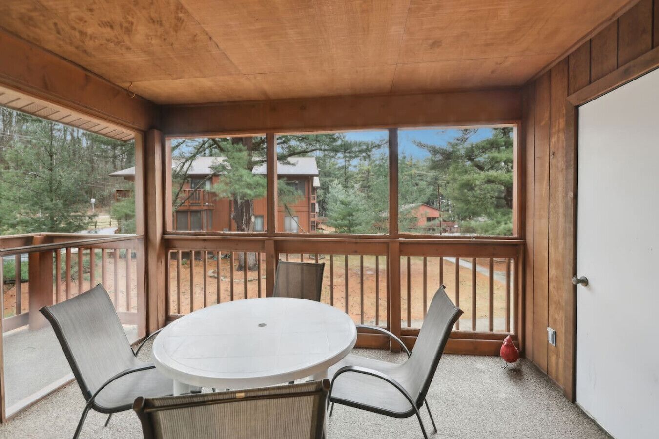 A covered outdoor area with a round table and four chairs.
