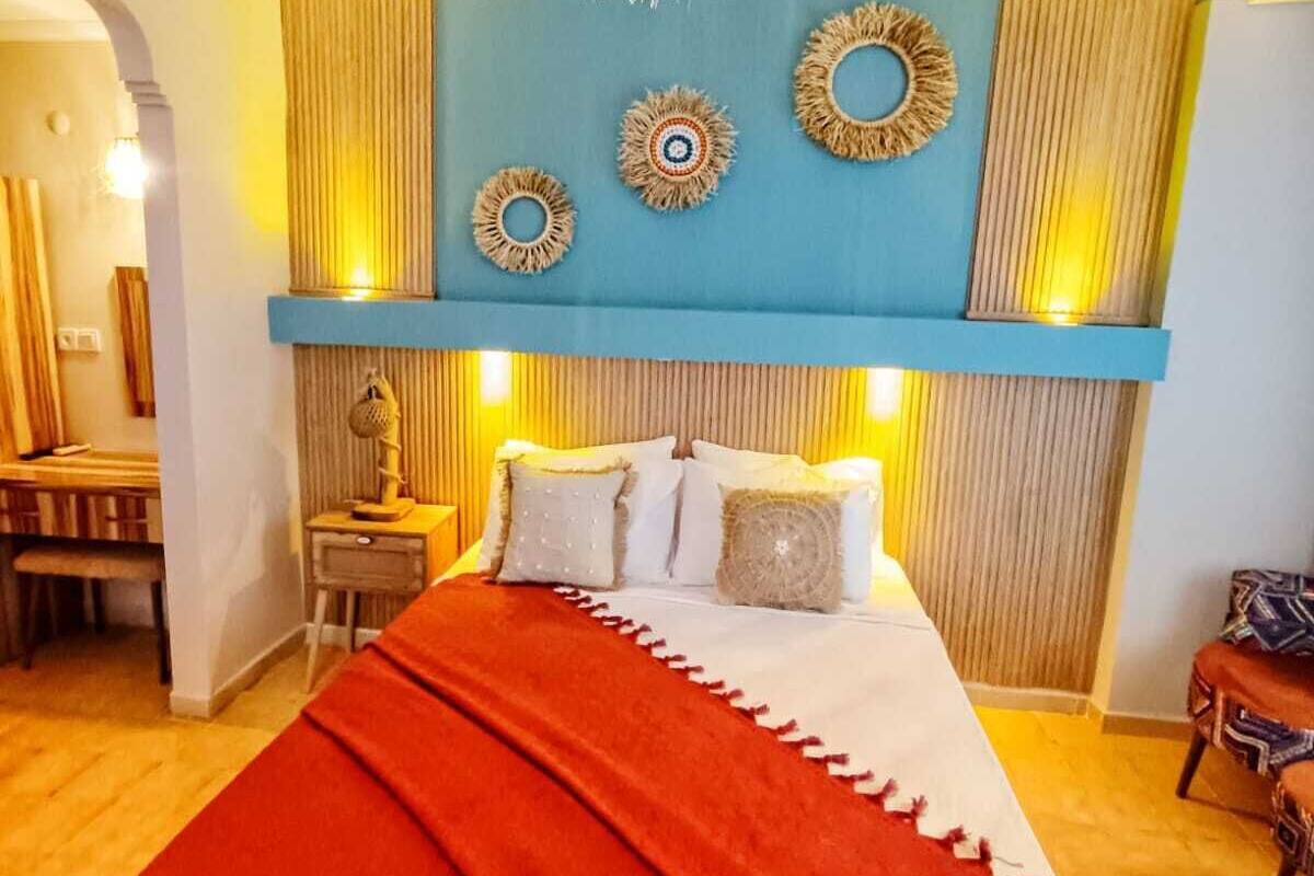 A bedroom with a bed, a desk, and a chair.