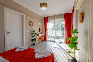 A bedroom with a bed, a plant, a vanity, and a view of the outdoors. - SUREYYA HOTEL BY KALIPSO (Fethiye)
