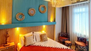 A bedroom with a bed, a hanging lamp, and a window with curtains. - SUREYYA HOTEL BY KALIPSO (Fethiye)