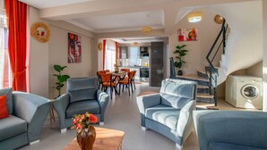 A modern living room with a dining area, kitchen, and staircase. - SUREYYA HOTEL BY KALIPSO (Fethiye)