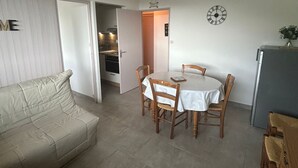 Ein kompakter Wohnbereich mit Essbereich, Küchenzeile und einer Couch.