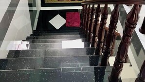 A staircase with a wooden handrail and black marble steps.