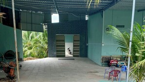 A covered outdoor area with tiled flooring, a metal gate, and a motorcycle parked inside.