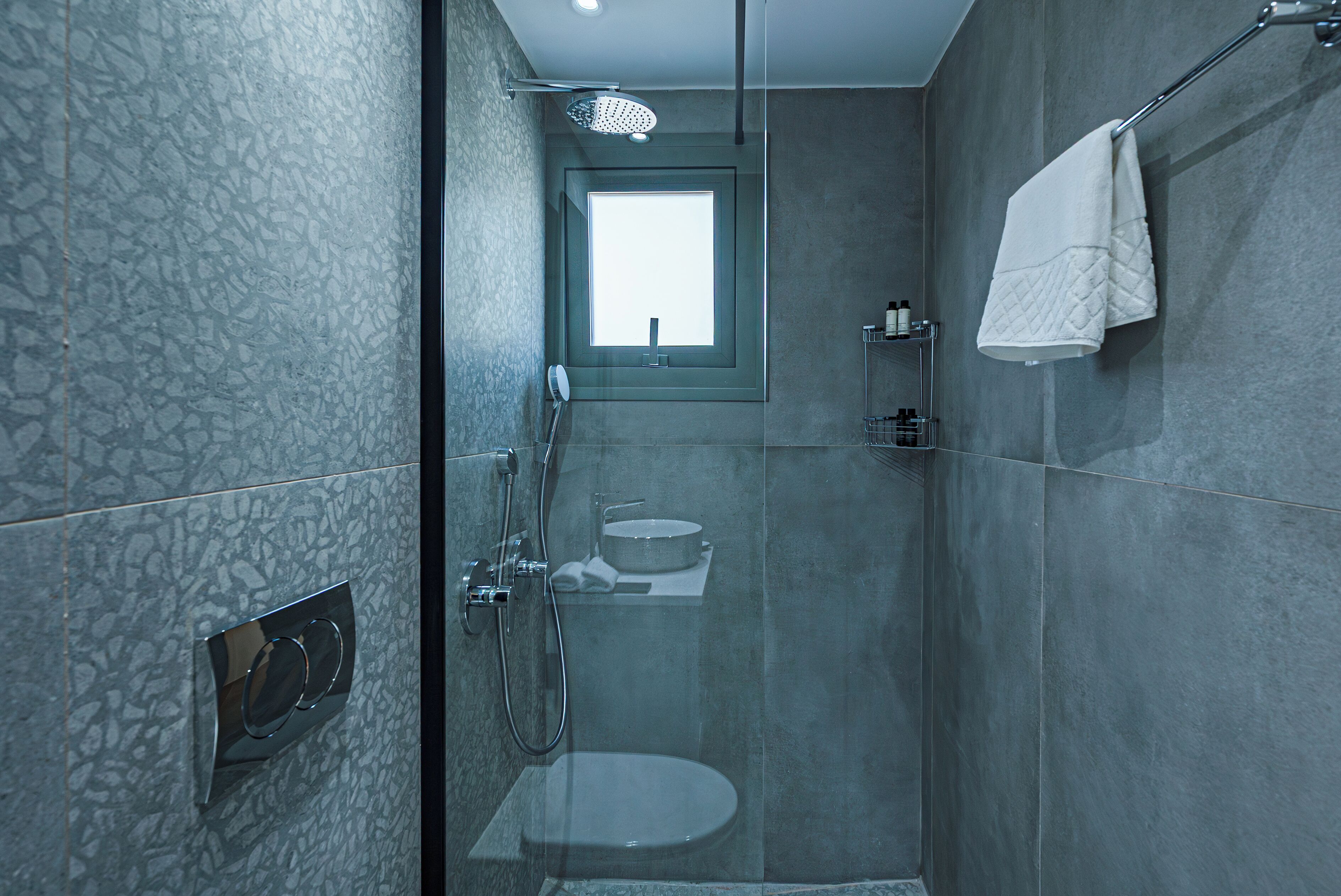 Un baño moderno con cabina de ducha de vidrio, inodoro y lavamanos.