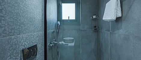 Un baño moderno con cabina de ducha de vidrio, inodoro y lavamanos.