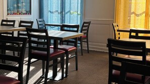 A dining area with multiple tables and chairs, large windows with blue curtains, and a view of the outside. - Hotel Le Lacuzon (Moirans-en-Montagne)