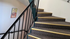 A staircase with black railings and patterned carpet. - Hotel Le Lacuzon (Moirans-en-Montagne)
