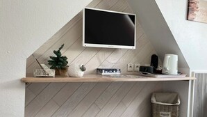 A modern kitchen with a built-in TV, wooden countertop, and various kitchen appliances. - Hotel Le Lacuzon (Moirans-en-Montagne)
