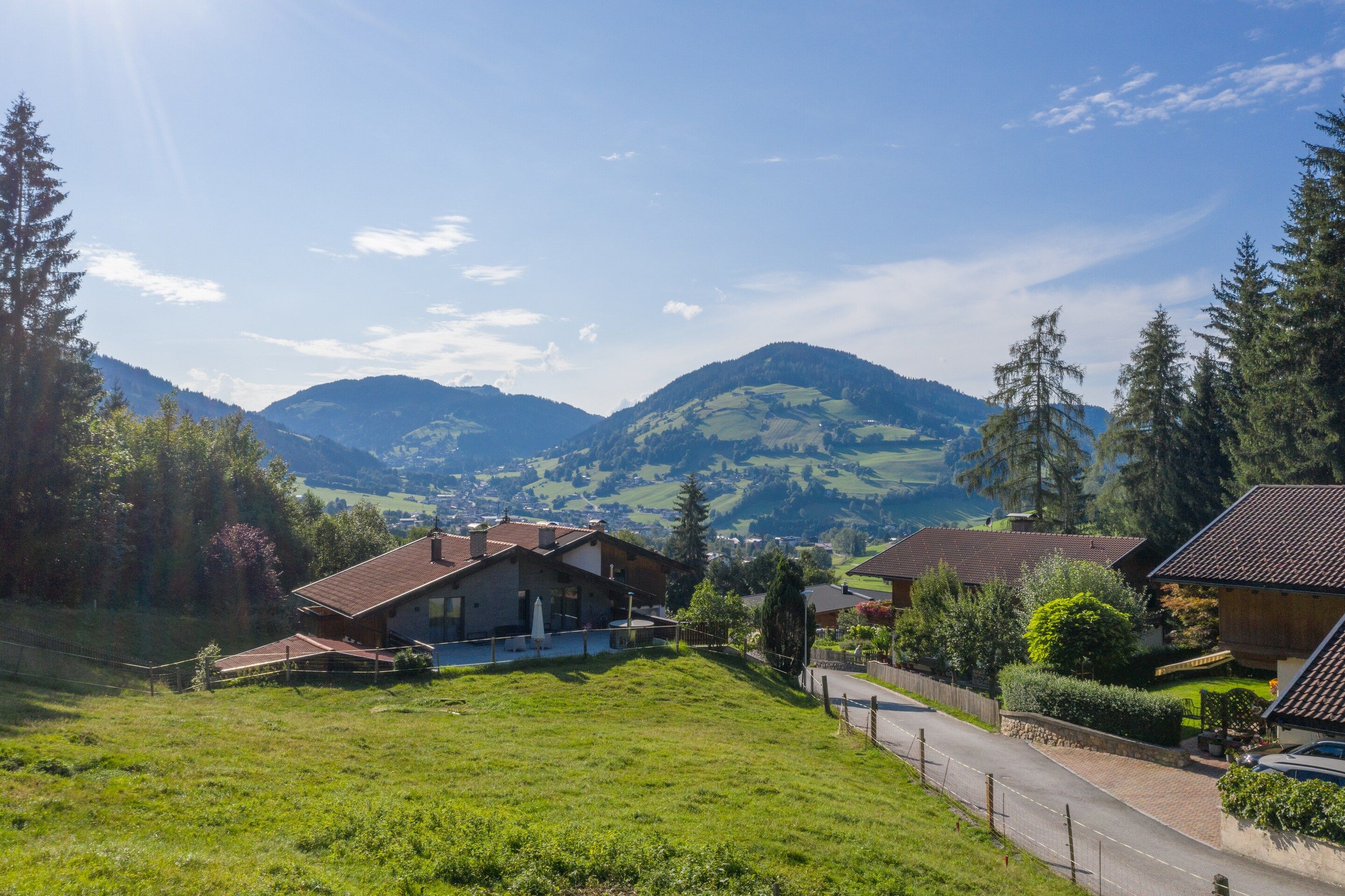 A residential area with houses, a road, and a mountain range in the background.